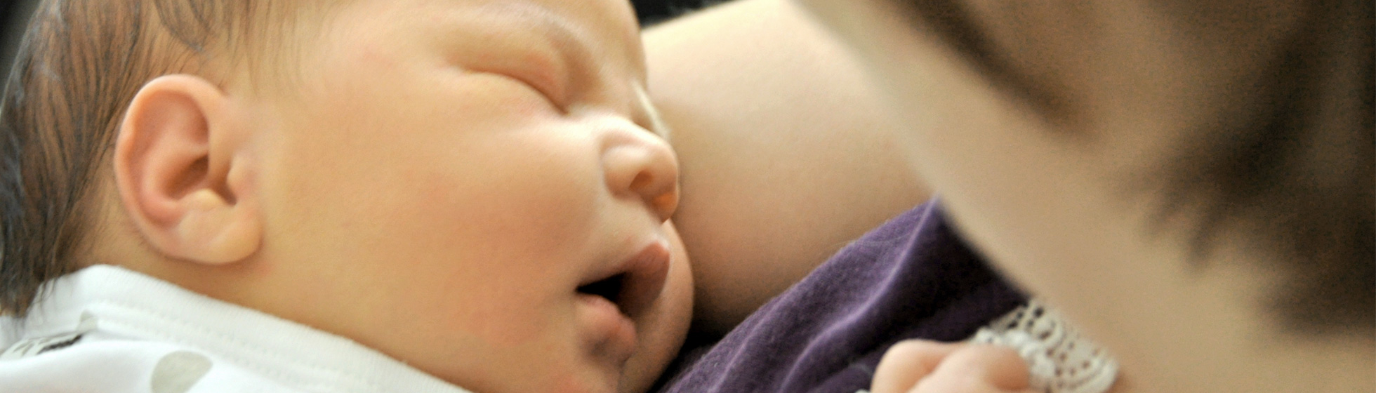 Mother having cuddles with newborn baby Archie Seeto